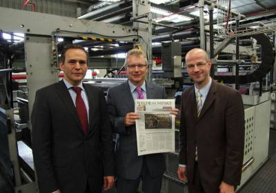 Volker Wehmeyer, Thomas Drensek i Holger Benthack prezentuj personalizowany egzemplarz "Welt Kompakt"